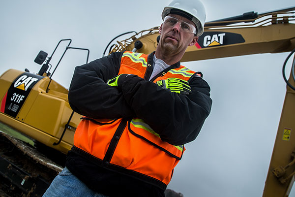 Cat worker standing near equipment